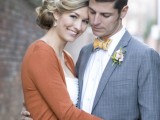 a striped gold bow tie and a pastel floral boutonniere accent the grey suit and add chic to it