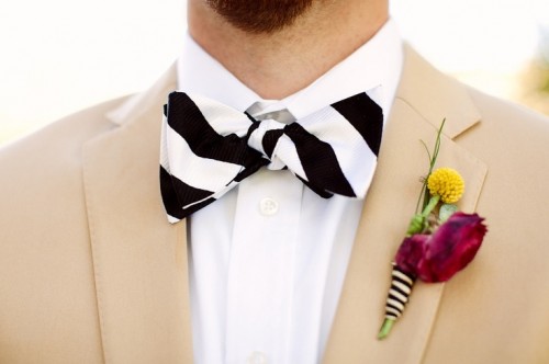 a tan suit, a striped bow tie, a colorful floral boutonniere for a bold and cool summer groom's look