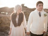 a groom wearing a white calbe knit sweater, a white shirt and a black tie plus black pants looks very chic, cozy and wintry-like