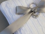 a white calbe knit ring pillow and a grey ribbon bow is a lovely idea for a winter or Christmas wedding