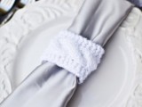 an elegant winter wedding place setting with a vintage plate, a silver napkin with a white cable knit napkin ring is a lovely idea