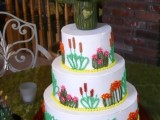 a white wedding cake with cactus decor and a cactus topper is a creative idea for a festival or desert wedding