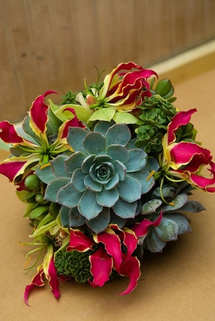 a bright wedding bouquet of bold blooms and succulents is a creative and chic idea to go for