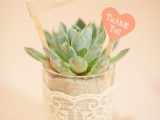 a cute potted succulent with tags wrapped in lace is a cool and simple wedding favor
