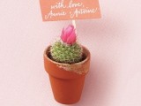 a potted blooming cactus with a topper is a nice wedding favor idea that is eco-friendly at the same time