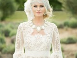 a romantic vintage wedding dress of crochet lace, with long sleeves and a statement necklace plus a cool cap veil with embellishments