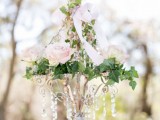 a refined crystal chandelier with blush roses and foliage plus a blush bow is a romantic and chic idea for a garden bridal shower