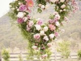 a heart-shaped wreath of greenery, pastel and neutral blooms is a cool decoration for a garden bridal shower