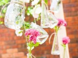 bright and pastel blooms in jars and bottles hanging over the space feels very relaxed and garden-like