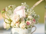 a floral teacup with a saucepan and some neutral and pastel blooms and baby’s breath for a refined garden bridal shower