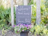 a large vintage urn with purple and pink blooms and a chalkboard sign for a vintage garden bridal shower