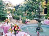 a refined vintage garden bridal shower space with pink tablescapes, bright blooms, petals in the fountain and chic chairs