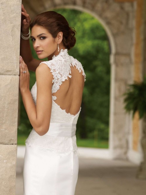 a fitting wedding dress with a lace bodice, a high neckline, no sleeves, a keyhole back and a sleek skirt is a chic idea to rock