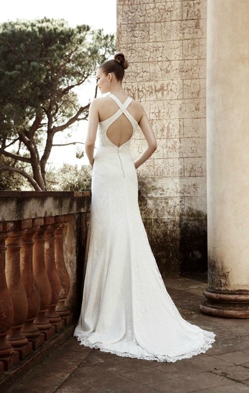 a creative lace mermaid wedding dress with a criss cross back plus a keyhole element and a short train plus a row of buttons
