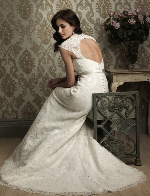 a sophisticated vintage lace mermaid wedding dress with a high neckline, cap sleeves, a keyhole back on buttons and a silk sash