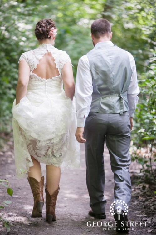 a lace A-line wedding dress with a high neckline, a keyhole back and cap sleeves plus cowboy boots for a rustic wedding