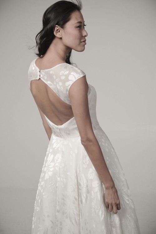 a modern enchanting A-line wedding dress with floral prints, a keyhole back on buttons, a high neckline and no sleeves