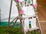 a spring bridal shower seating chart with tables, pink blooms and blooming branches
