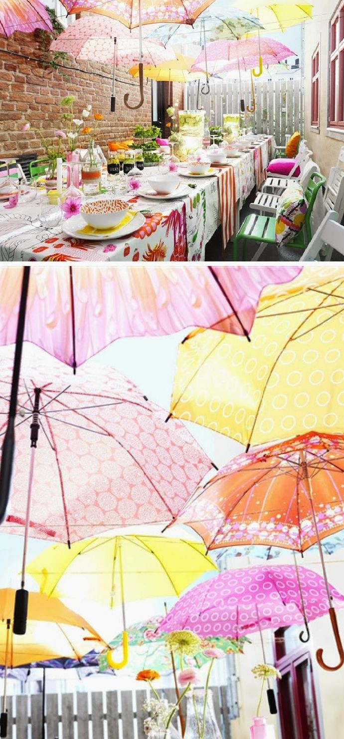a colorful backyard bridal shower with bright umbrellas over the table, floral linens, colorful tableware and bright pillows