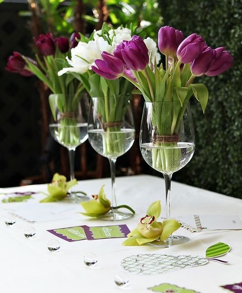a quirky card table with purple and white tulips in tall glasses for a spring bridal shower