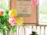 vintage books and a vintage memo board with bright paper flowers and signs and greeenery is simple and lovely decor for a vintage bridal shower
