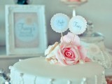 a vintage white bridal shower cake with delicate edible pearls and beads, pink roses and cake toppers is a chic and lovely idea for a vintage bridal shower