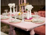 a small and sweet vintage bridal shower table in pink, with doilies and vintage plates, with white blooms in vases and vintage books is amazing