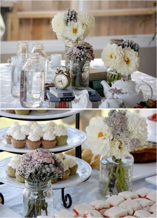 a vintage bridal shower table with a vintage stand with cupcakes, white blooms, vintage books stacked and a vintage clock is a great idea