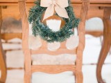 accent the chairs with little evergreen wreaths with bows to give the venue a traditional Christmas feel