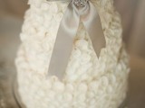 a winter bridal shower cake topped with an elegant sparkling bow is a chic idea with a classic feel