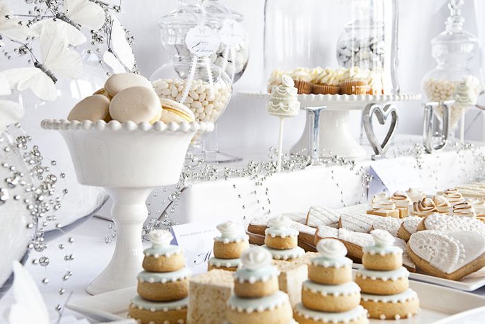An all white dessert table with cookies, cupcakes, macarons and other stuff will create a fairy tale feel
