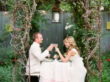 a fairy-tale woodland wedding arch of branches and vines, with greenery, neutral bloomsand leaves is romantic