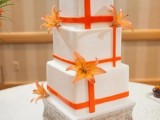 a square wedding cake with orange ribbons and orange fall leaves is a great idea for a fall or beach wedding