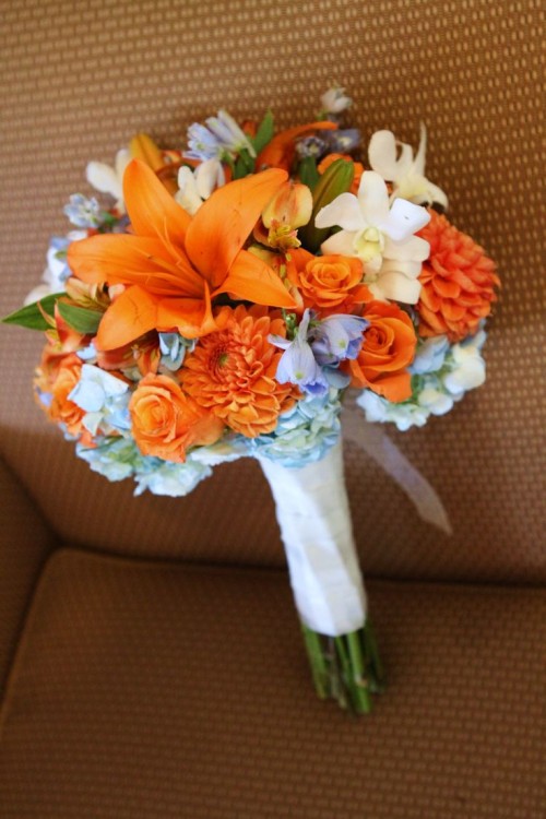 a bold wedding bouquet of orange and light blue blooms is a great idea for an orange beach wedding