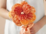 a creative wedding bouquet of orange seashells wiht a pearl is a unique idea for an orange beach wedding, it’s a bold idea to DIY