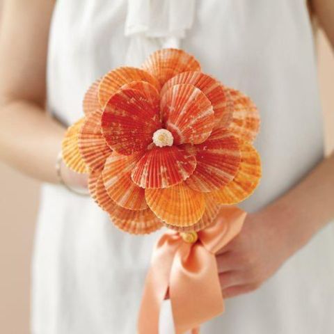 a creative wedding bouquet of orange seashells wiht a pearl is a unique idea for an orange beach wedding, it's a bold idea to DIY