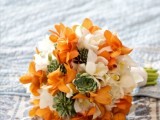 a bold wedding bouquet of orange and white blooms, with succulents and a white wrap is a gorgeous idea for an orange wedding