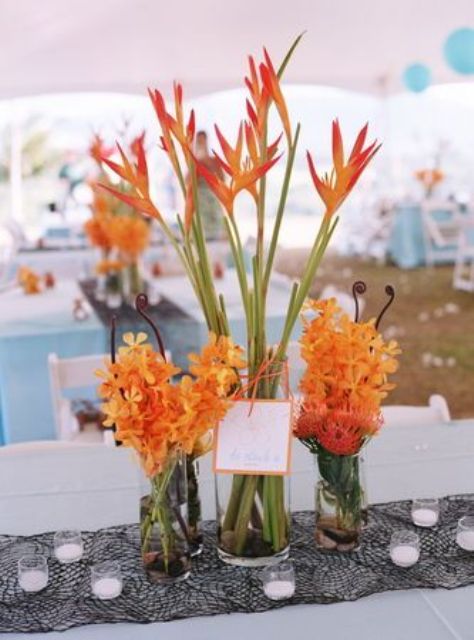 a bright orange bloom wedding centerpiece is a great idea for a colorful beach wedding, use tropical blooms for a more spectacular look