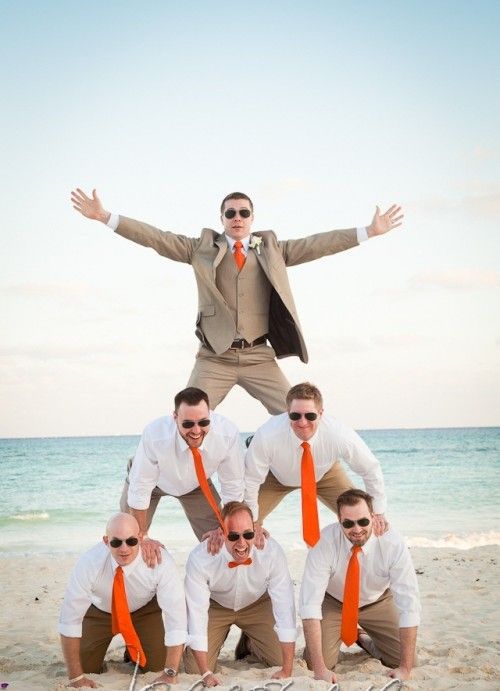 the groom and groomsmen wearing tan suits, white shirts and orange ties for a fun beach wedding