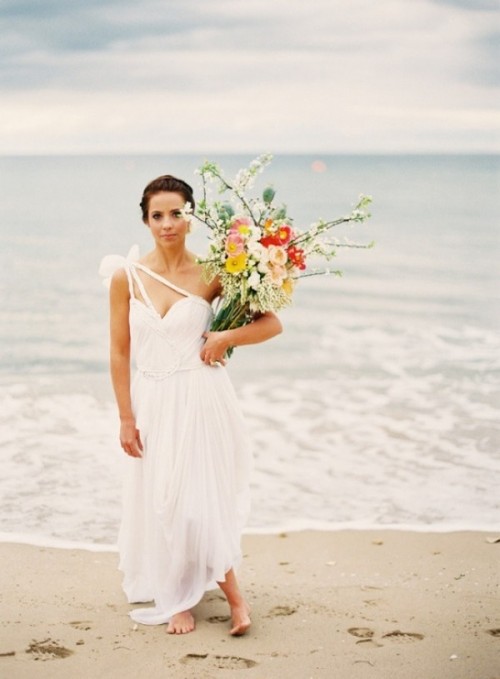 a one shoulder A-line wedding dress with ribbons, a tulle skirt is a lovely idea for a beach wedding