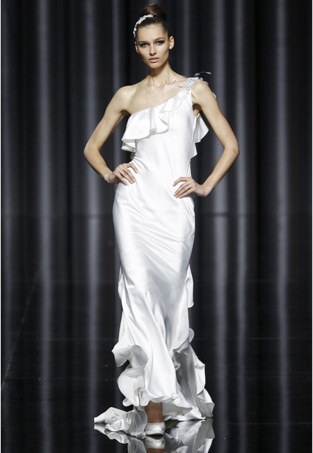 a modern plain one shoulder wedding dress with a ruffle skirt edge and a train for a modern romantic bride