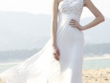 a stylish one shoulder A-line wedding dress with a patterned bodice and a pleated skirt with a train is a bold and cool idea