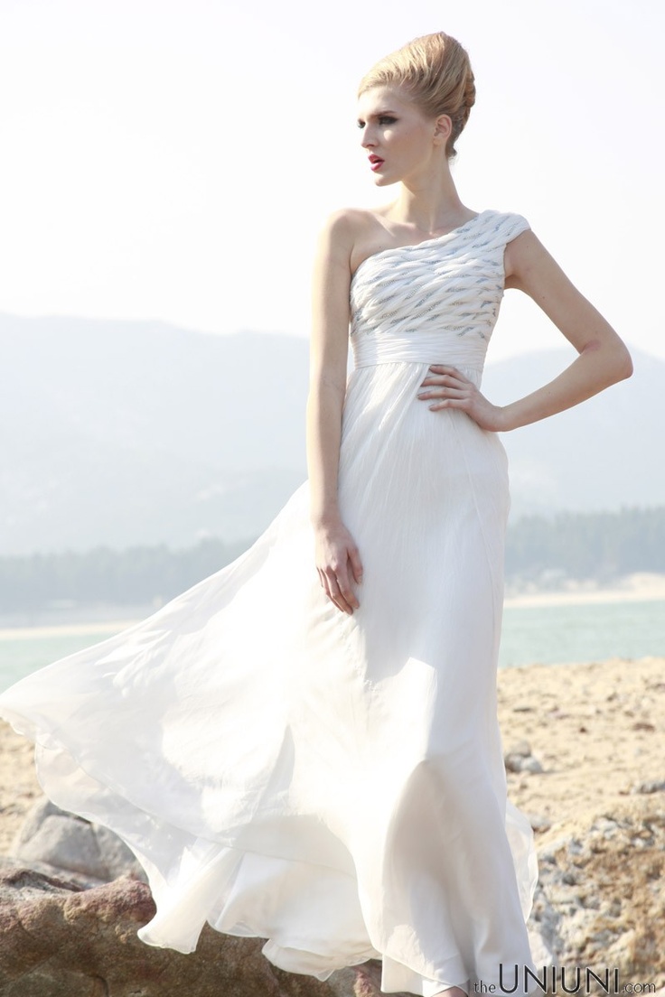 A stylish one shoulder A line wedding dress with a patterned bodice and a pleated skirt with a train is a bold and cool idea
