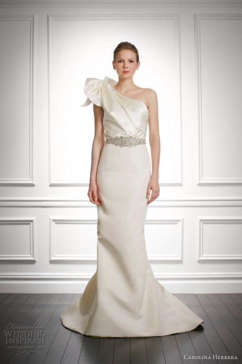 a sophisticated plain one shoulder wedding dress with a shiny pleated bodice and ruffles on the shoulder, a plain skirt with a train and an embellished sash