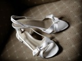 simple white strappy heeled sandals with small bows are a nice and trendy idea for a summer bride