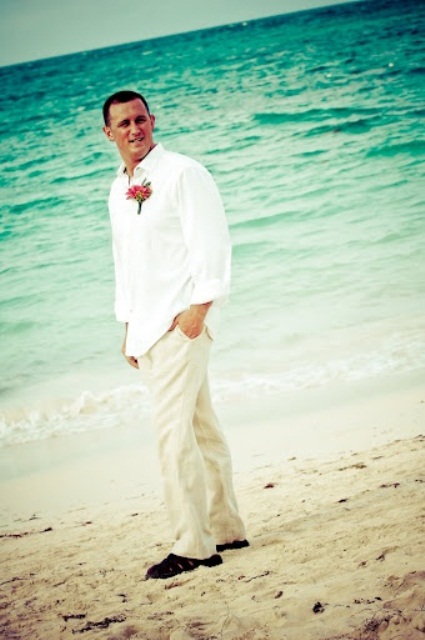 tropical groom's attire with tan pants, a white shirt and a floral boutonniere plus sandals