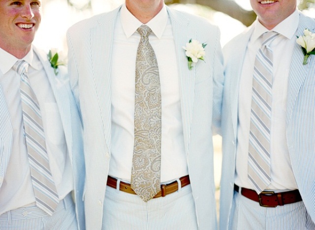 light blue thin stripe suits, white shirts, striped ties, neutral flower boutonniere to give a nod to the sea theme