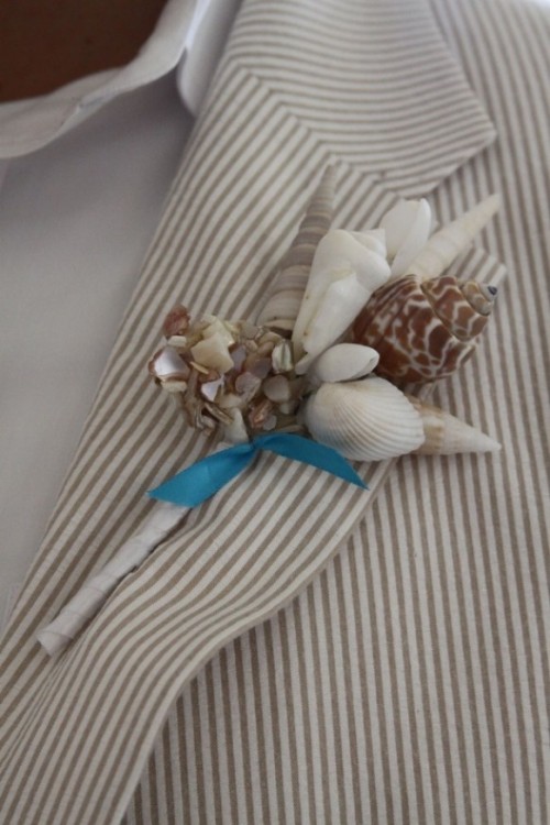 a thin striped suit, a white shirt and a seashell boutonniere for a dapper beach look