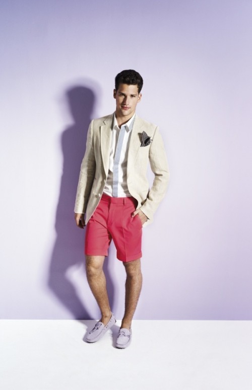 a bold and non-traditional look with coral shorts, grey moccasins, a creamy jacket, a striped shirt