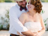 navy pants, a white shirt, a colorful striped tie and a hat for a dapper beach groom’s outfit